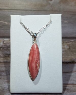 Elongated rhodochrosite pendant showing natural pink layers and polished finish