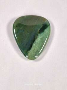 Moss Agate guitar pick showcasing dendritic landscape patterns