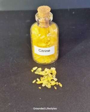 Clear glass bottle filled with polished citrine gemstone grains