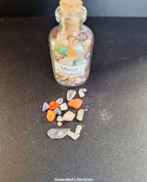 Clear bottle filled with assorted mixed gemstone grains of various colors