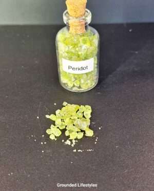 Clear glass bottle filled with vibrant green peridot gemstone grains