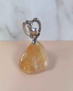 Handcrafted pewter heart featuring a cat nestled in the center, mounted on a yellow citrine tumbled stone