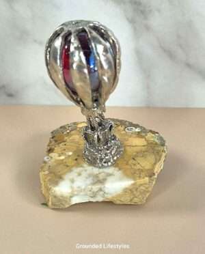 Handcrafted pewter hot air balloon figurine perched atop a patterned Cobra Jasper stone