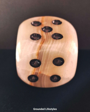 Polished gemstone dice carved from Pakistani onyx