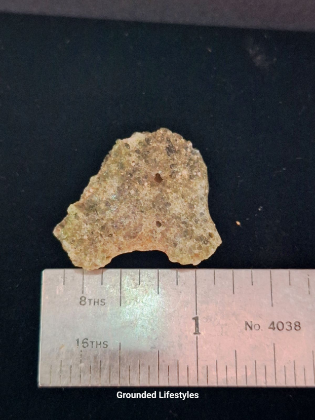Authentic 4.0 g Trinitite fragment showing olive-green glass and vesicles.