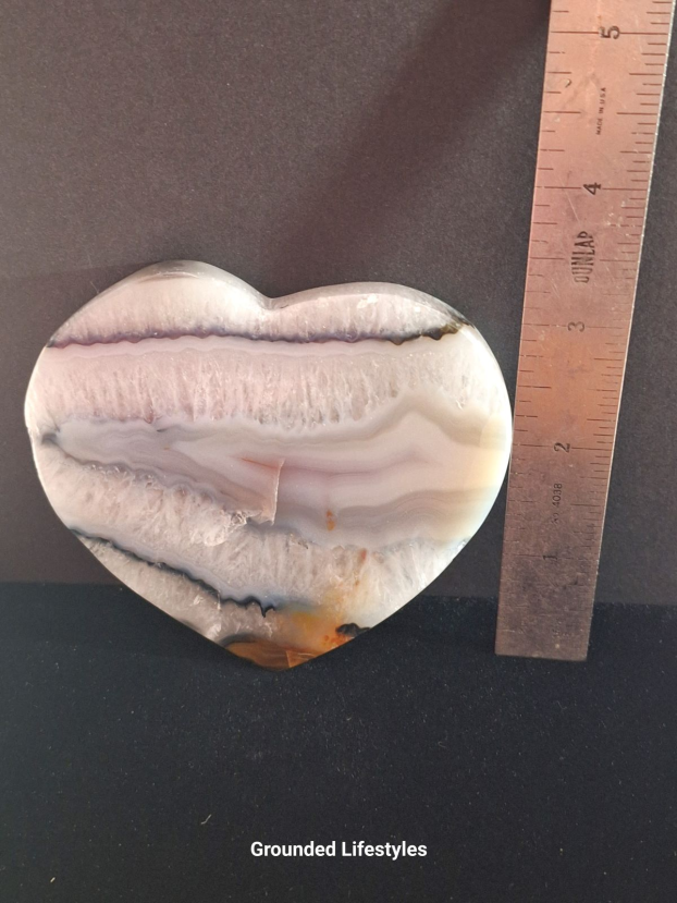 Polished Brazilian agate heart showing concentric banding and translucent tones