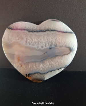 Polished Brazilian agate heart showing concentric banding and translucent tones