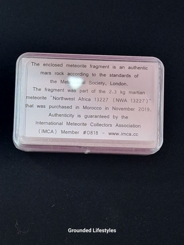 Genuine Mars meteorite fragment in labeled display box.