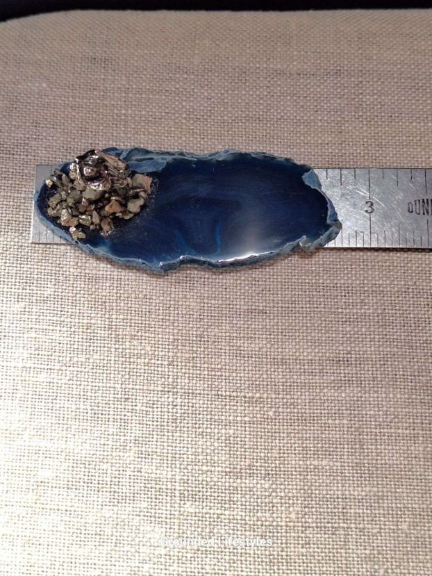 pewter miner with axe and pyrite grains displayed on polished agate slice