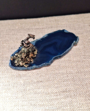pewter miner with axe and pyrite grains displayed on polished agate slice