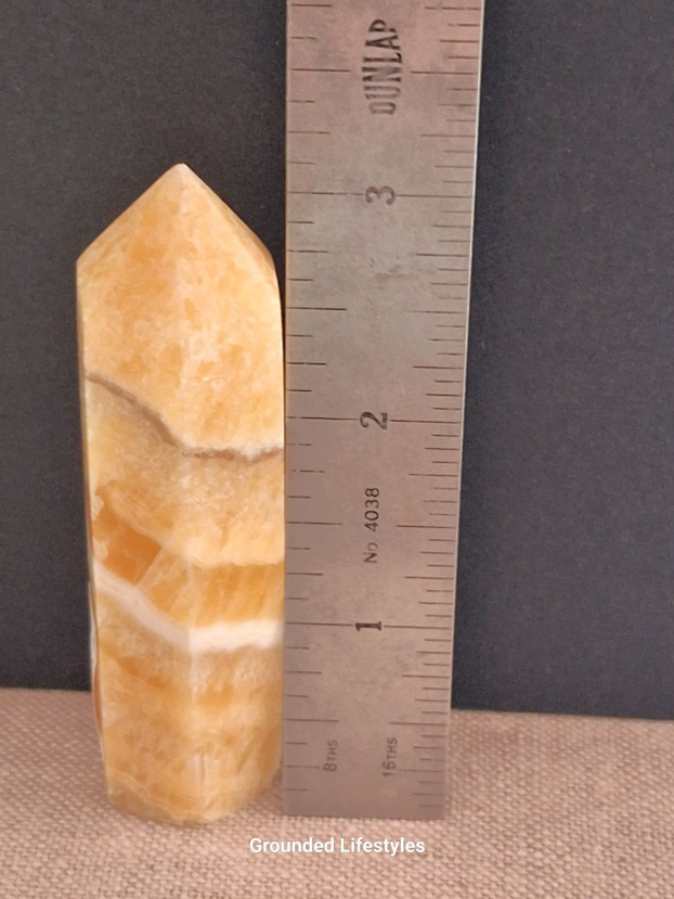 orange calcite point 3.25 inch showing layered banding